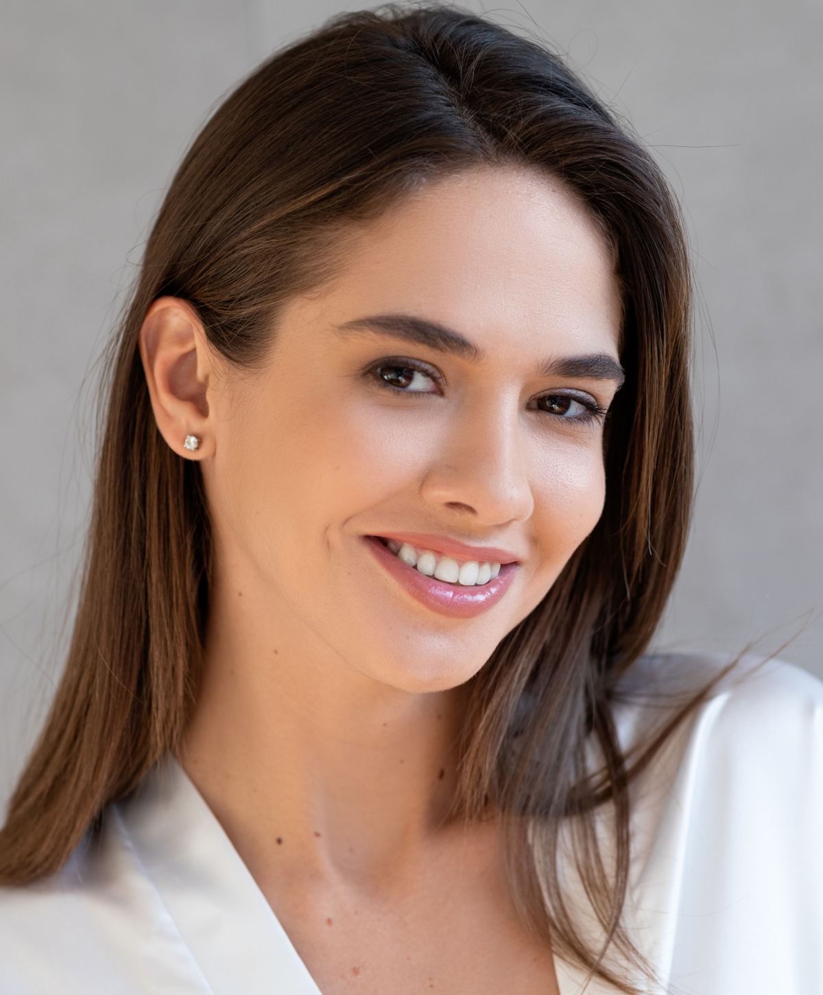 Smiling woman with long hair and earrings.