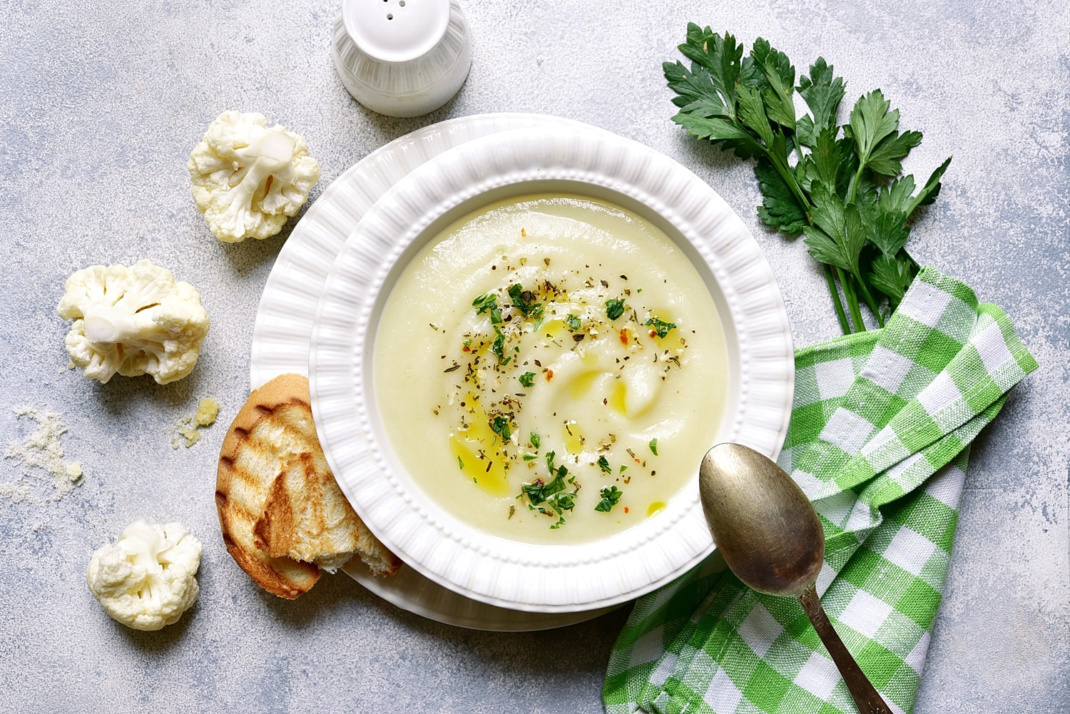 Creamy cauliflower soup with herbs and bread.