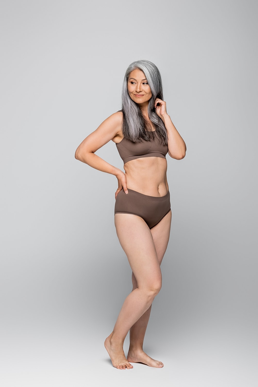 Woman in brown swimwear posing confidently.