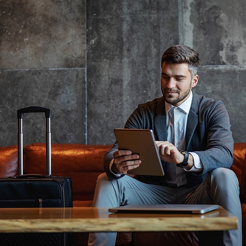 Businessman working on tablet in modern lounge.