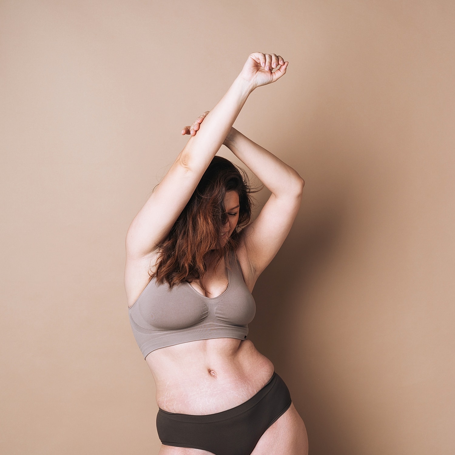 Woman posing in comfortable intimate apparel, soft lighting.