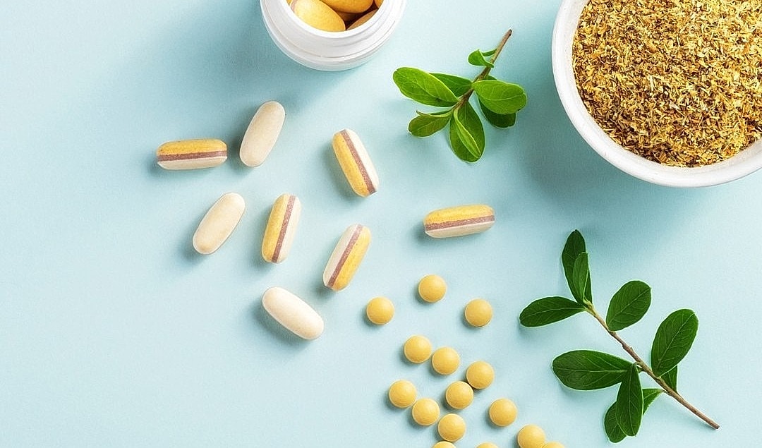 Assorted vitamins and herbs on a blue background.